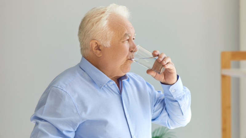 White-Haired Chubby Senior Man Drinking Water